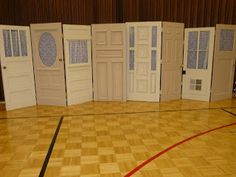 an indoor basketball court with several doors on each side