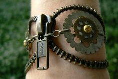 a close up of a person's arm wearing a bracelet with gears on it