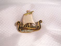 Rare Coro c1940's Gold Plated Sterling, Enameled Viking Ship Brooch Beautiful vintage brooch, hand enameled over gold plated sterling. The brooch is 2 inches long in good condition. There is very small scratch in the enamel on the bottom of the sail near the mast pole. Victorian Gold Enamel Pin, Victorian Style Gold Enamel Pin, Vintage Gold Enamel Lapel Pin, Collectible Gold Enamel Pins, Antique Gold Enamel Brooches, Victorian Enamel Pin Collectible, Victorian Enamel Collectible Pin, Antique Enamel Pin For Formal Occasions, Gold Enamel Lapel Pin