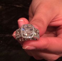 a person holding a diamond ring in their hand