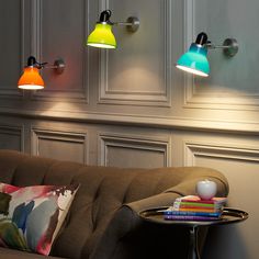 three colorful lights are hanging on the wall above a couch and coffee table in a living room