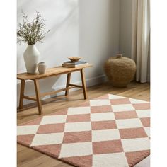 a living room with a checkered rug on the floor and a wooden coffee table