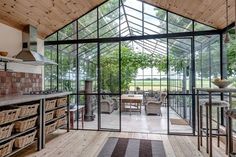 the inside of a house with glass walls and wood flooring on the outside side