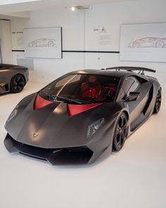 two very nice looking sports cars in a room with white walls and flooring,