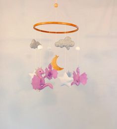 a crib mobile with stars and clouds hanging from it