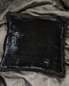 a black velvet pillow sitting on top of a bed