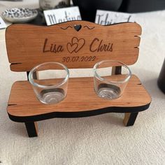 two glasses are sitting on a wooden bench