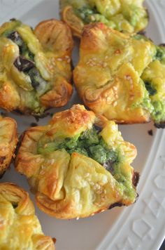 some broccoli and cheese pastries on a white plate