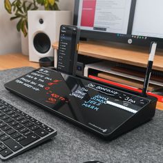 an electronic device sitting on top of a desk next to a keyboard