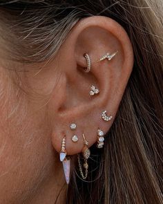 a close up of a person with ear piercings on their ears and behind the ear