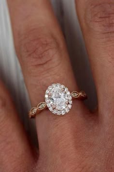 a woman's hand with a diamond ring on top of her finger and an engagement band