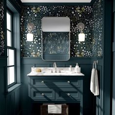 a bathroom with green walls and floral wallpaper on the walls, along with two sinks