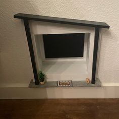 a tv mounted to the side of a wall with a plant on top of it