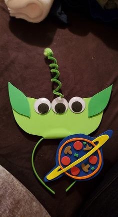 a green mask with googly eyes and a string attached to it