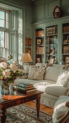 a living room filled with lots of furniture and flowers in vases on the coffee table