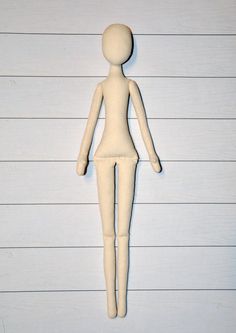 a wooden mannequin standing in front of a white wall with horizontal lines on it