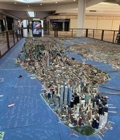 a large model of the city is on display in an empty mall floor with blue tarp covering it