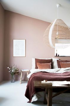 a bedroom with pink walls and white flooring has a large bed in the middle