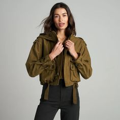 The Finnian is a showstopper, our take on a military-inspired utility coat with a high funnel neck and deep hood made from 100% Japanese sateen cotton. With an oversized yet cropped cut, it’s feminine with lots of attitude. Military details abound such as functional epaulets at the shoulders, three-dimensional patch po Cropped Utility Jacket With Flap Pockets, Utility Cropped Jacket For Winter, Fall Combat Hooded Utility Jacket, Combat Style Khaki Parka For Fall, Combat Style Cotton Outerwear For Fall, Winter Cropped Utility Outerwear, Cropped Utility Winter Outerwear, Cropped Utility Outerwear For Winter, Fall Combat Parka With Cargo Pockets