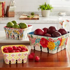 three bowls filled with fruit sitting on top of a kitchen counter next to a cutting board