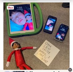 an elf is laying on the floor next to some cell phones and a notepad