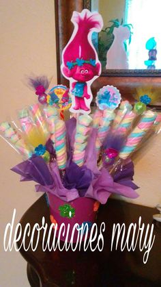 a vase filled with candy canes on top of a table