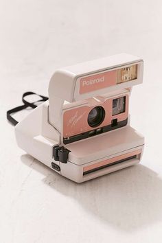 an old polaroid camera sitting on top of a white table