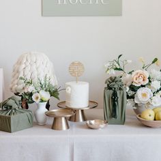 a table topped with white flowers and cakes