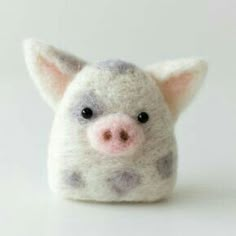 a small stuffed pig sitting on top of a white table