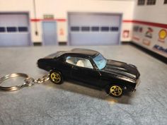 a black car keychain sitting on top of a table next to a garage