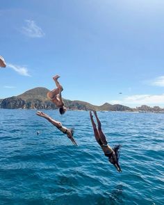 two people diving into the ocean from a boat