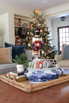 a living room with a christmas tree in the corner and decorations on the coffee table