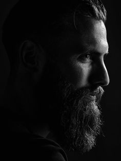 black and white photograph of man with beard looking off to the side, in profile