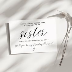 a piece of paper with the words sister written on it next to a single flower