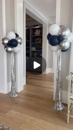 two tall silver and black balloons in the middle of a hallway