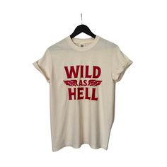 This faded distressed Wild as Hell shirt is perfect to dress up or wear casual! Wild as Hell Shirt, Vintage Graphic Tops for Women Faded Distressed T-shirt For Summer, Trendy Bleached Tops For Streetwear, Trendy Bleached Faded Top, Trendy Faded Bleached Top, Summer Casual Bleached Shirt, Casual Summer Bleached Shirt, Trendy Washed Summer Shirt, Distressed Graphic Tee Shirt In Relaxed Fit, Distressed Graphic Tee With Relaxed Fit