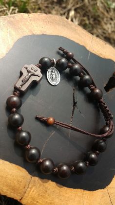 +. This is a Wooden Rosary Bracelet. +.It is knotted bracelet and it is adjustable . +.The crufix is carved in elevorate and three dementional shape. +.+.+.+.+. Materials +.+.+.+.+.+. Cross: Mpingo(Africa black wood) Beads : black wood +.+.+.+.+. Size +.+.+.+.+. Cross : 13.3mm(Width) *20mm(Height) Beads: 8mm +. Carved characters(e.g. baptismal name, name,etc) on back side +. please send me characters that you want. It's Free engraving +.Lead time is 3-7 business days. +.Delivery is currently bei Adjustable Wooden Beads Rosary Bracelet Gift, Adjustable Wooden Bead Rosary Bracelet Gift, Spiritual Brown Rosary Bracelet For Gift, Bracelet Rosary, Knotted Rosary, Mens Rosary, Wooden Rosary, Rosary Jewelry, Rosary Beads Catholic