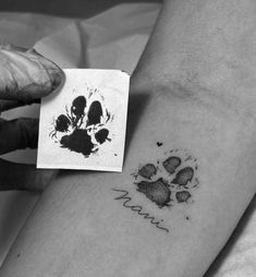 a black and white photo of a person's arm with a paw print on it