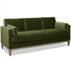 a green velvet couch with wooden legs and arm rests on an isolated white background,