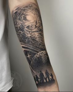 a man's arm with an image of the earth and people on it, in black and white