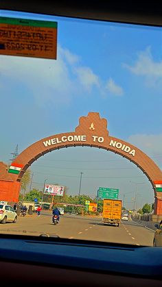 a welcome to noda sign is seen through the window of a car on a highway