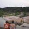 two people standing in front of a body of water