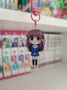 an anime character keychain is hanging from a shelf in a store or bookstore