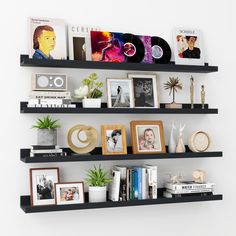 three black shelves filled with pictures and books