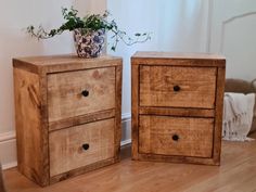 two wooden drawers sitting next to each other on top of a hard wood floor near a potted plant