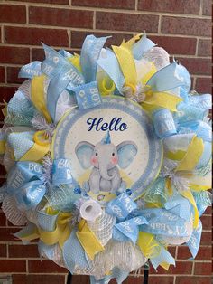 a blue and yellow baby wreath with an elephant on it's front door is shown