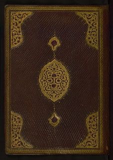 an old book with gold designs on it