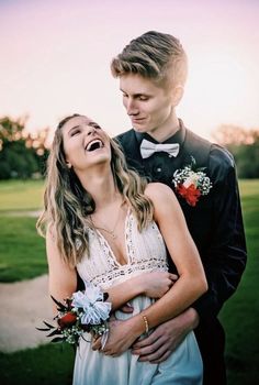 a young man and woman standing next to each other in front of the sun with their faces close together