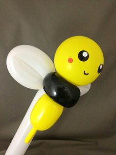 a yellow and black toy sitting on top of a white stick with a smiley face