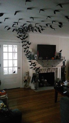 a living room filled with furniture and lots of birds flying over the fire place in the fireplace